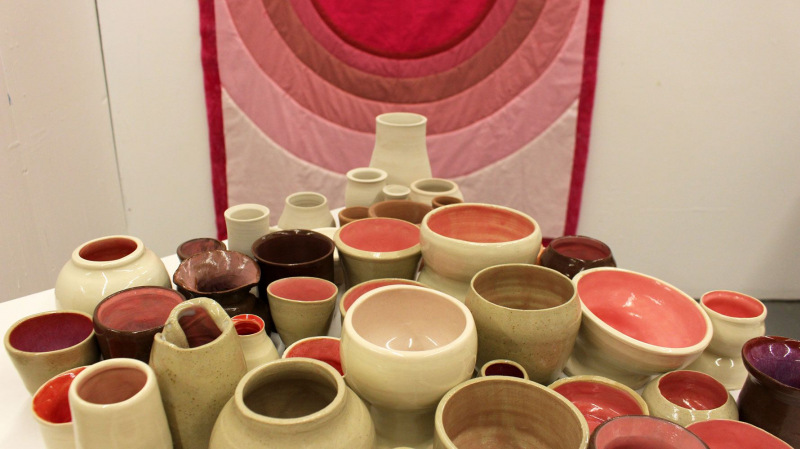 Installation photo of “Holding / Tenderness” (detail), 2021-2022; cotton, hand dyed wool batting, thread, ceramic greenware, bisque, and glazed vessels. Photo courtesy of the artist